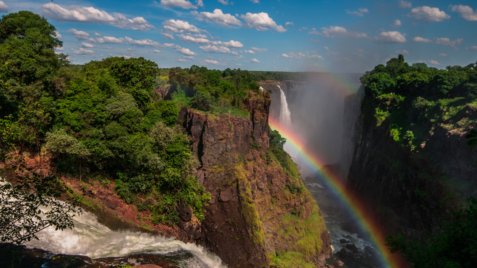 Радуга над водопадом на утесе 