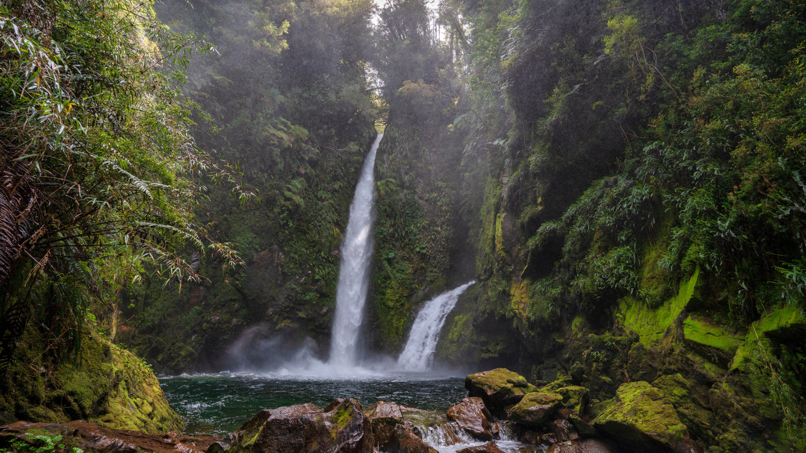 Водопад стекает со скалы в горную реку