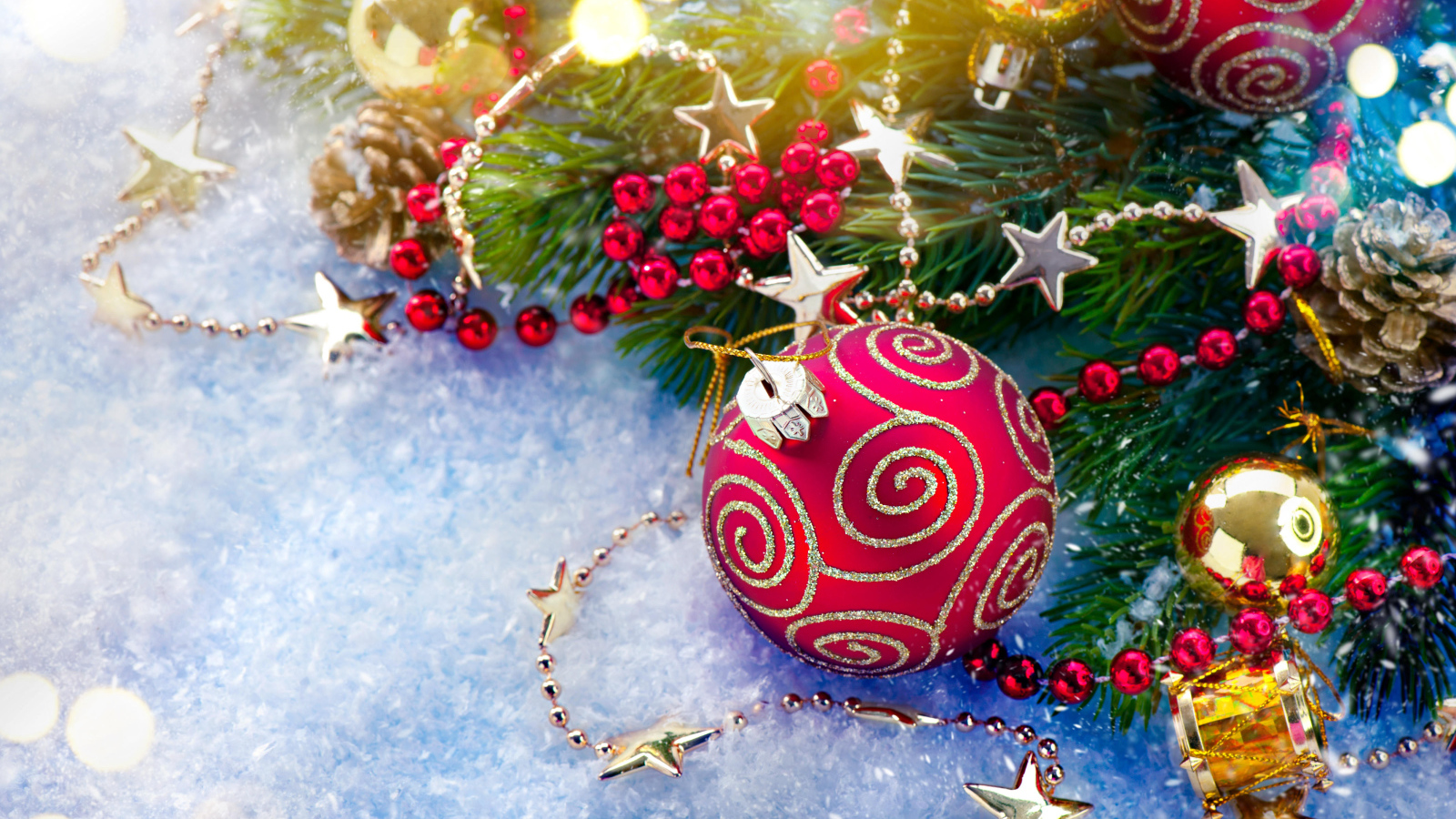 Яркие елочные украшения на снегу с веткой 