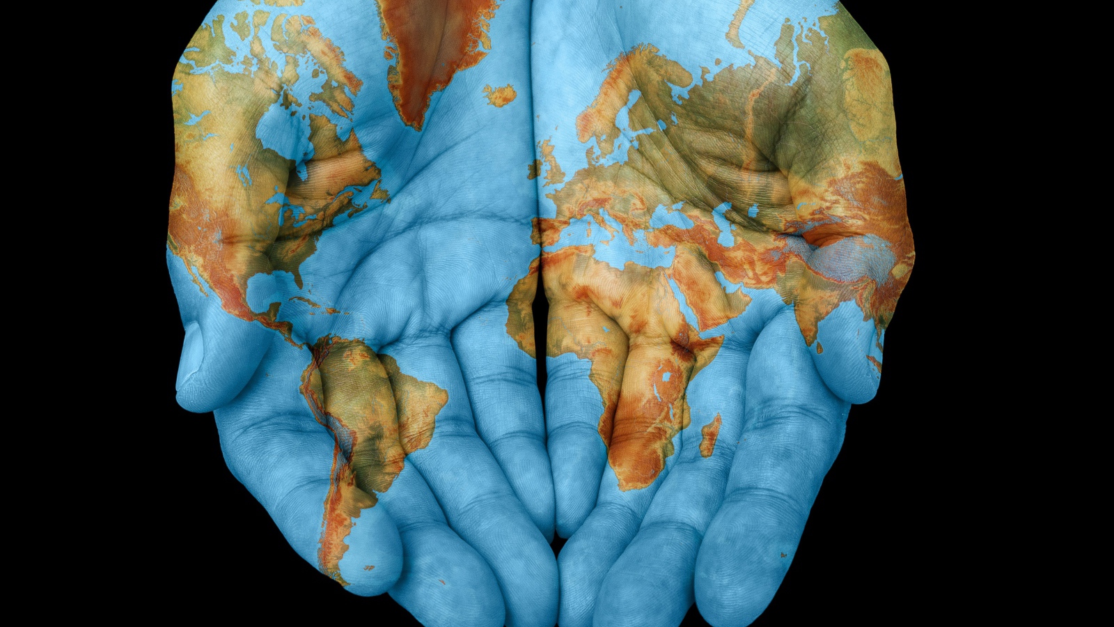 Руки с картой мира на черном фоне 