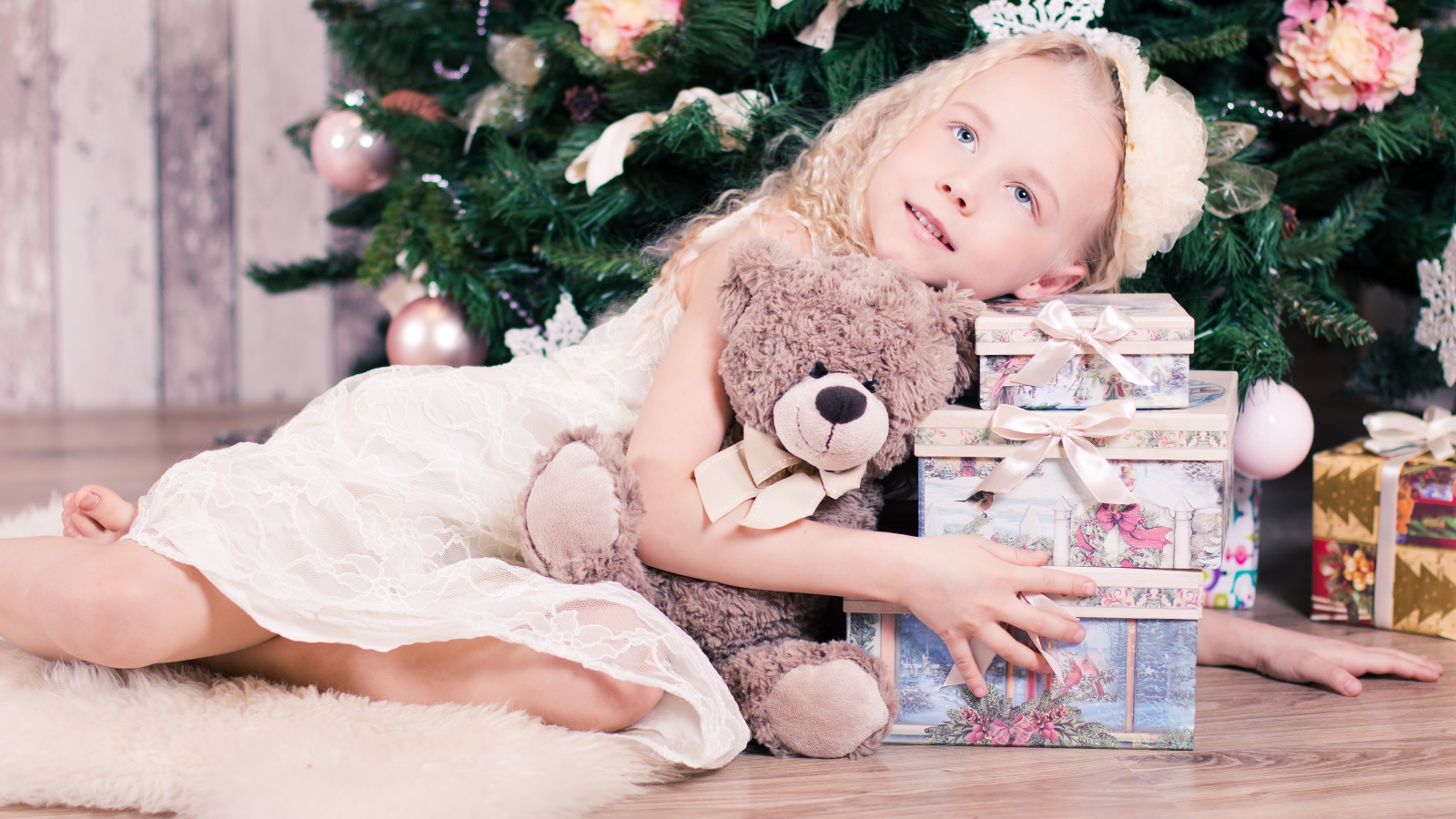 Красивая голубоглазая девочка с подарками у елки