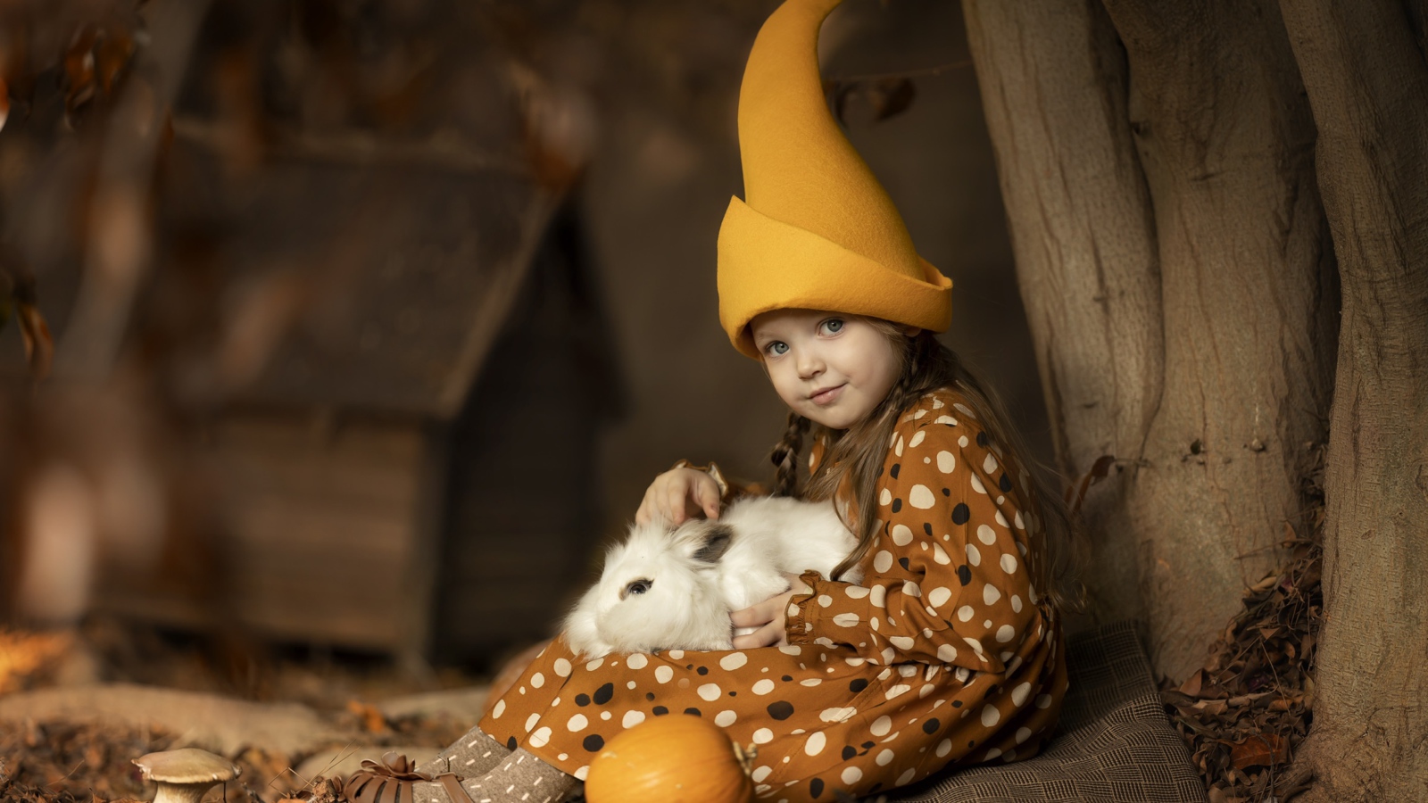 Маленькая смешная девочка в колпаке с кроликом