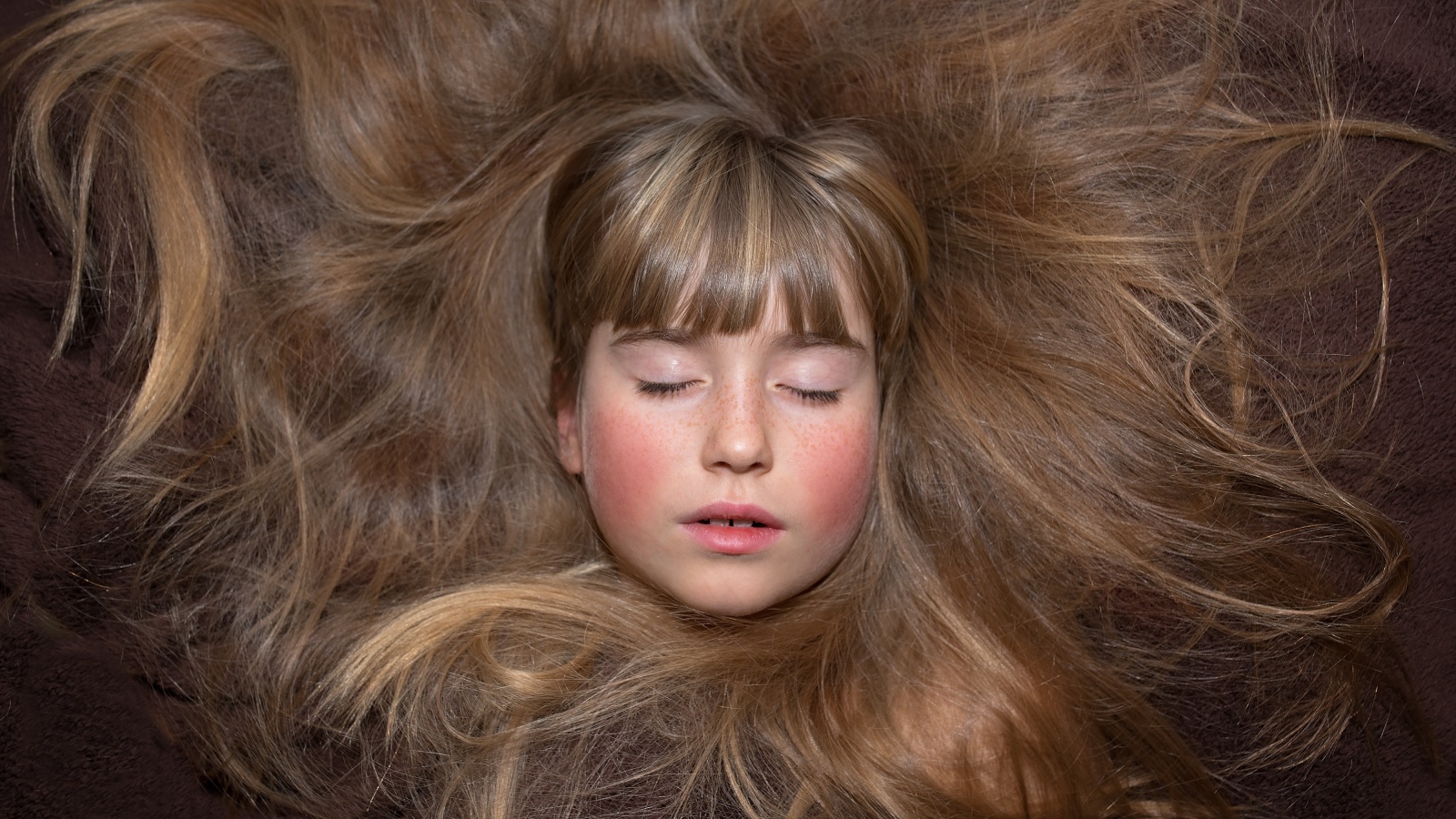 Маленькая спящая девочка с длинными волосами