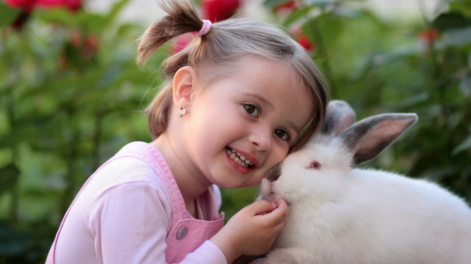 Маленькая улыбающаяся девочка с белым кроликом