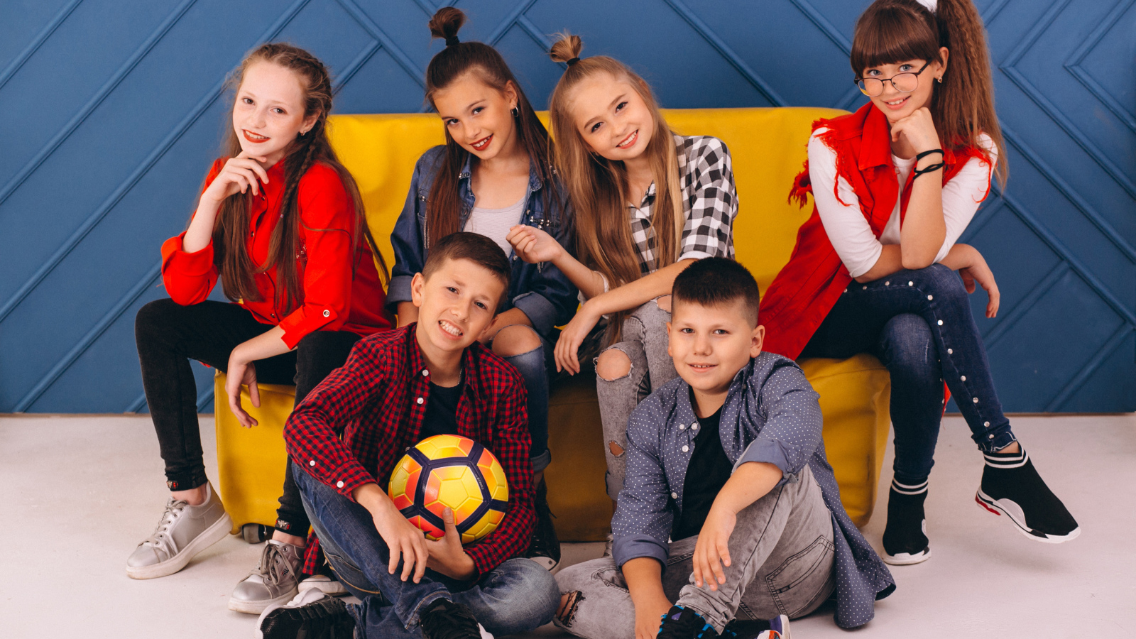 Много модных школьников сидят на диване