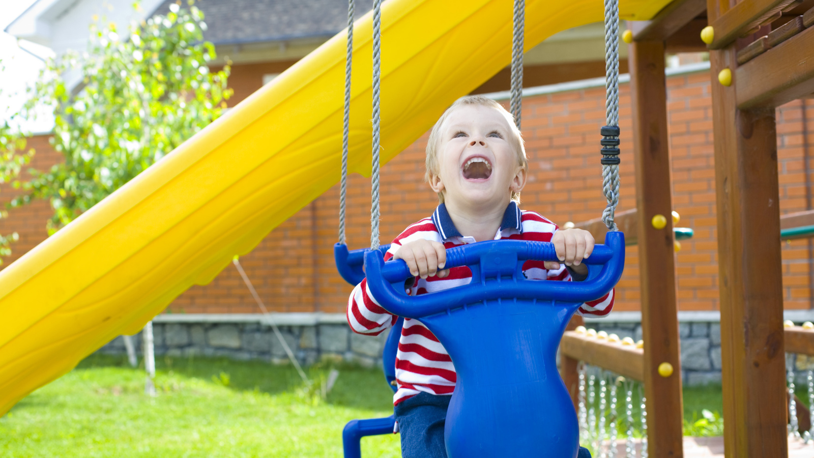 Улыбающийся ребенок на качели 