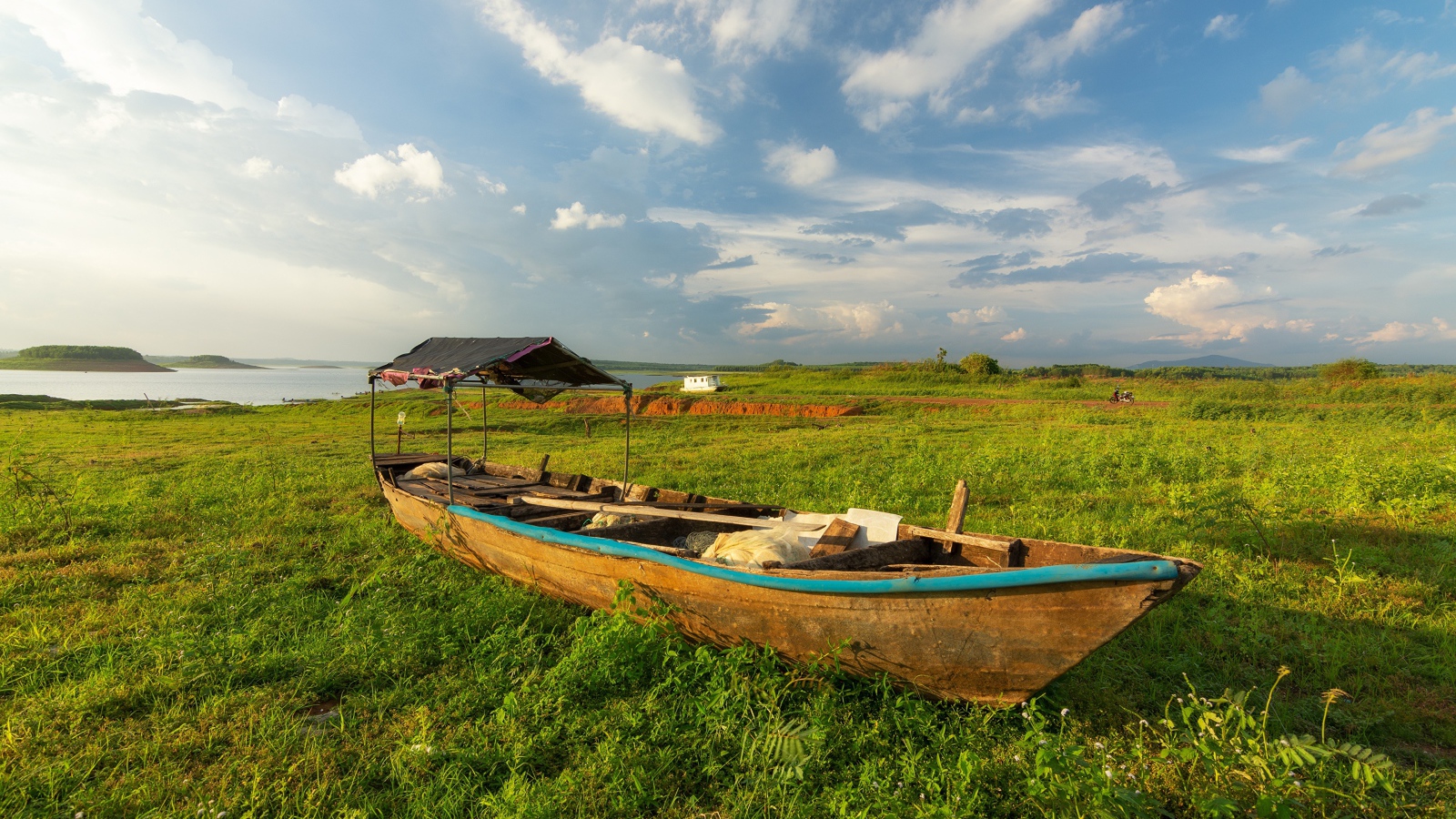 Большая деревянная лодка на зеленой траве