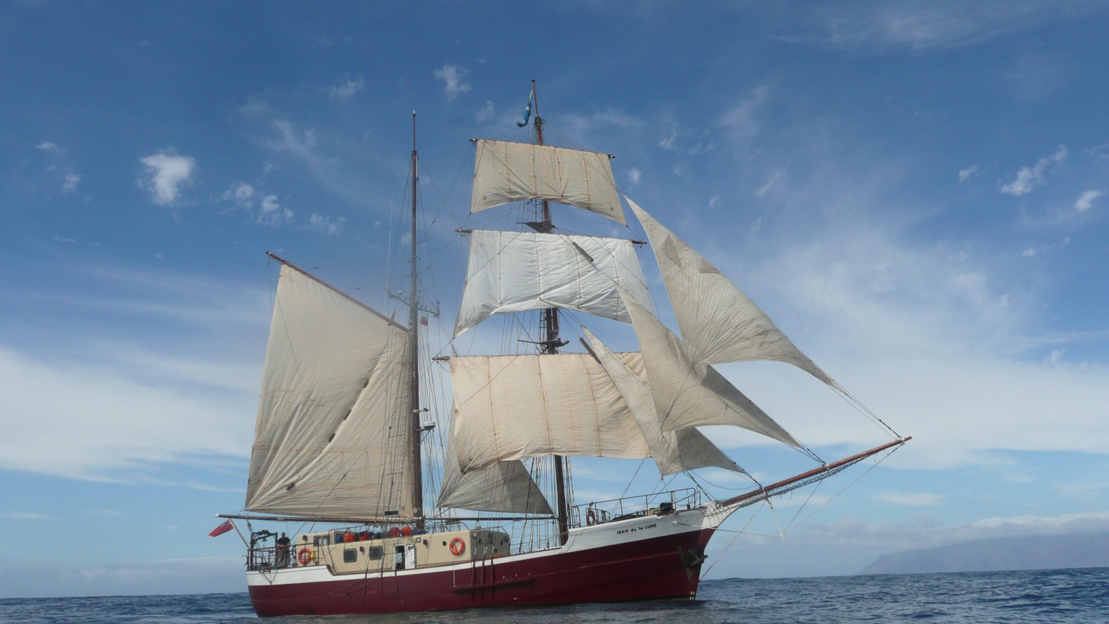 Больше судно с белыми парусами в море 