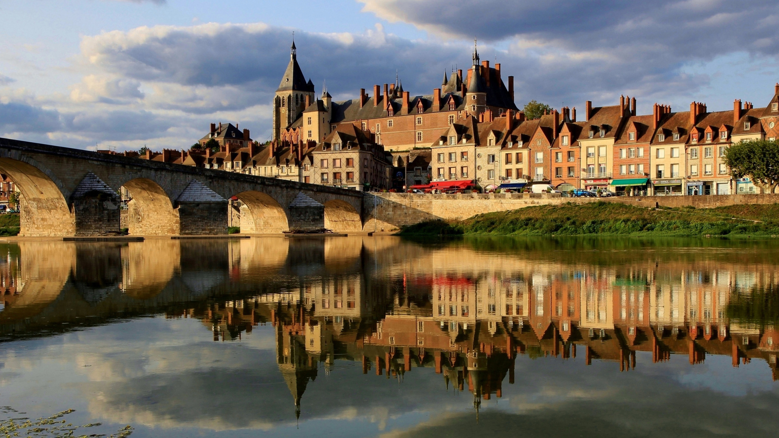 Большой дом отражается в реке у моста, Франция