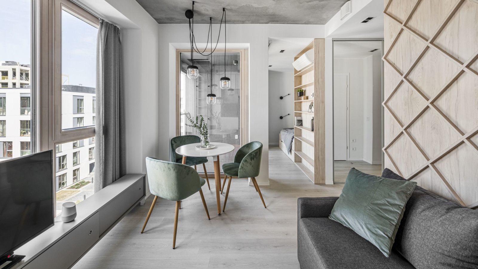 Стол  с креслами стоит у большого окна в квартире 