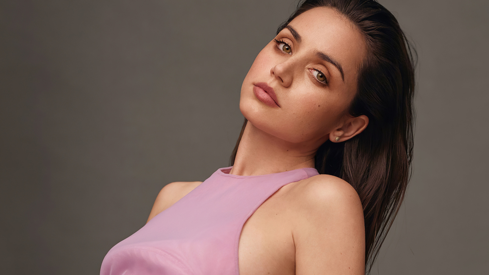 Актриса Ана де Армас на сером фоне в розовой кофте