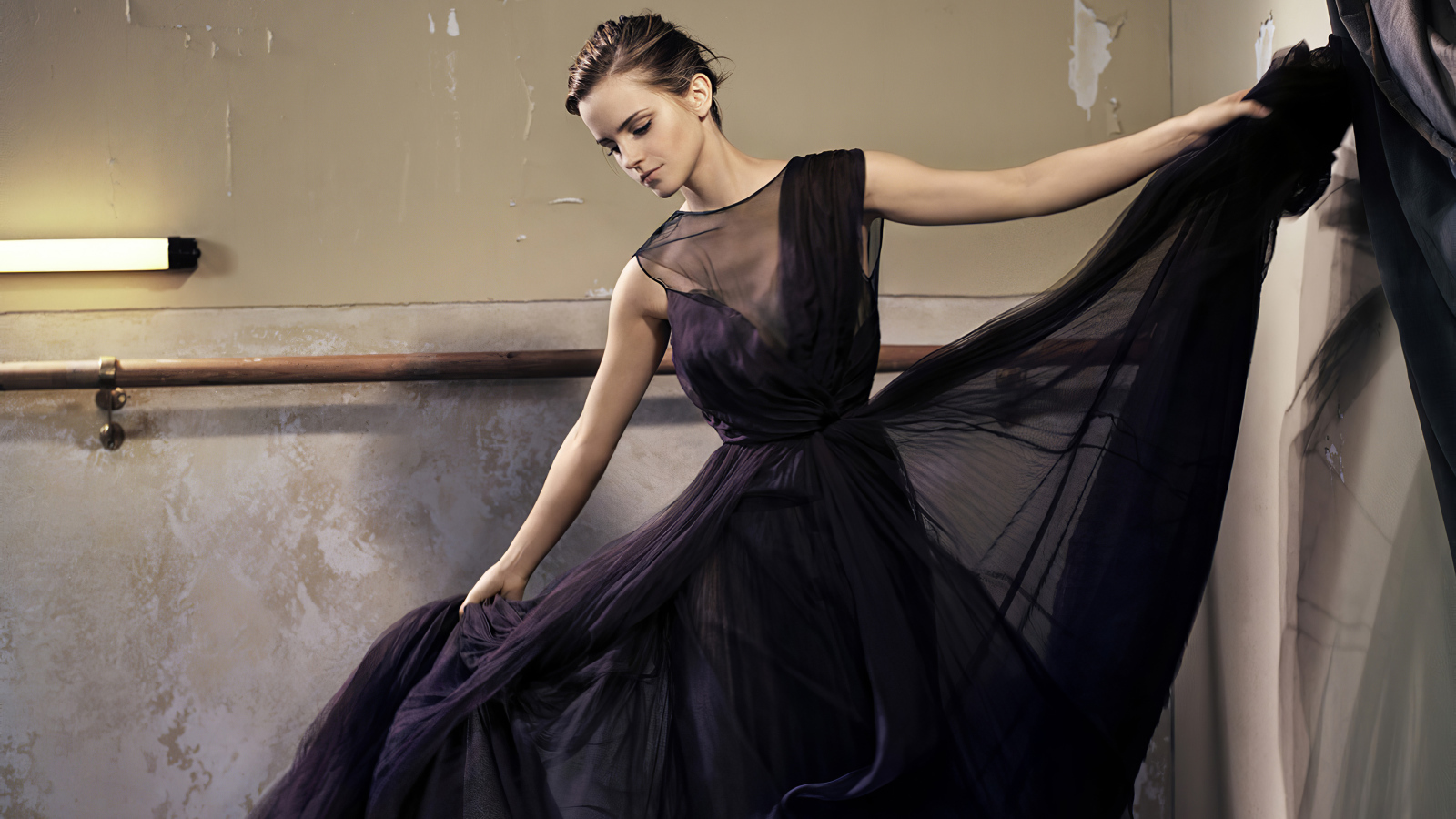 Актриса Эмма Уотсон в красивом черном платье в зале