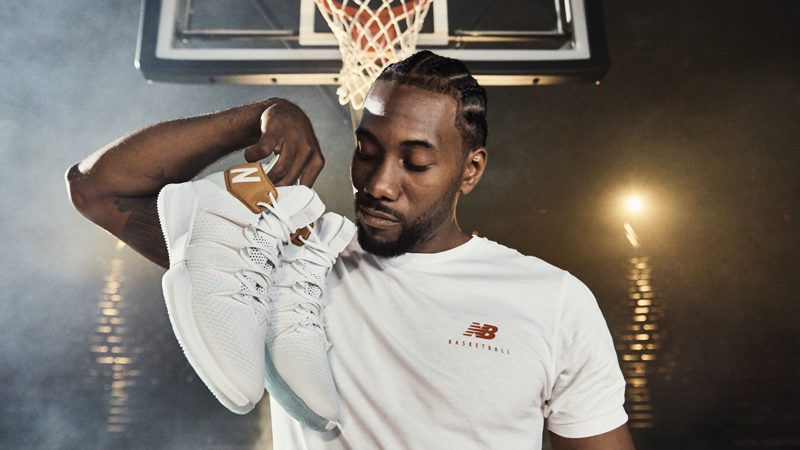 Американский баскетболист Кавай Леонард с кроссовками в руке