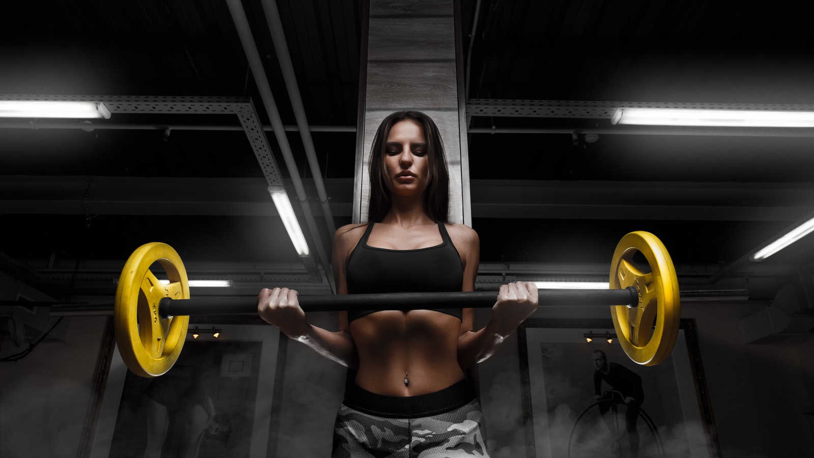 Спортивная стройная девушка поднимает штангу