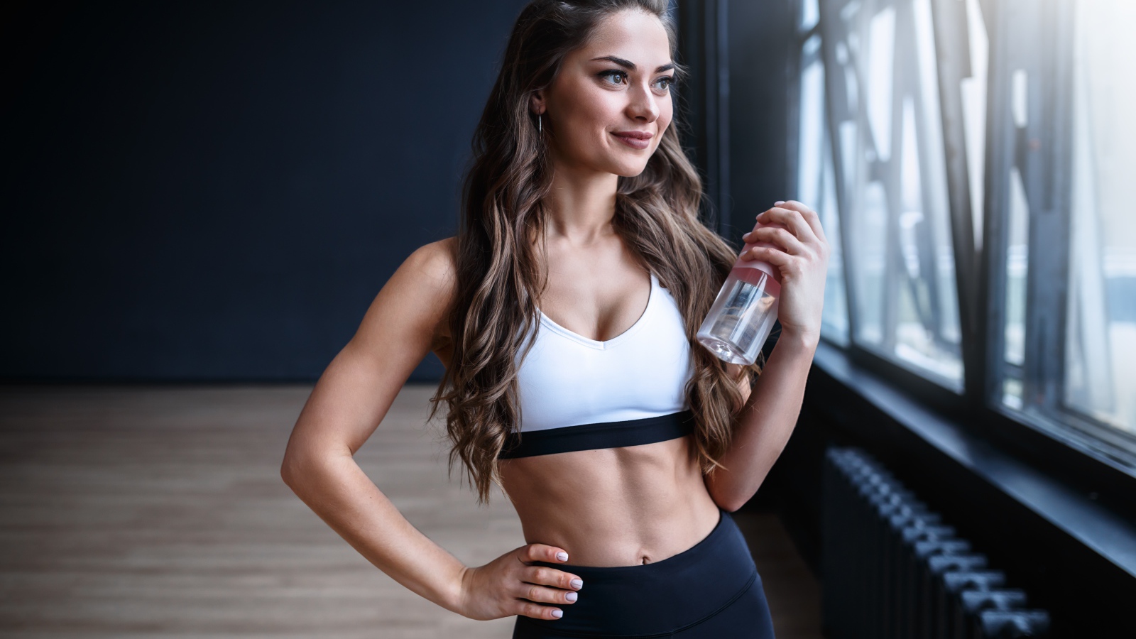 Beautiful athletic girl with a bottle of water in hand