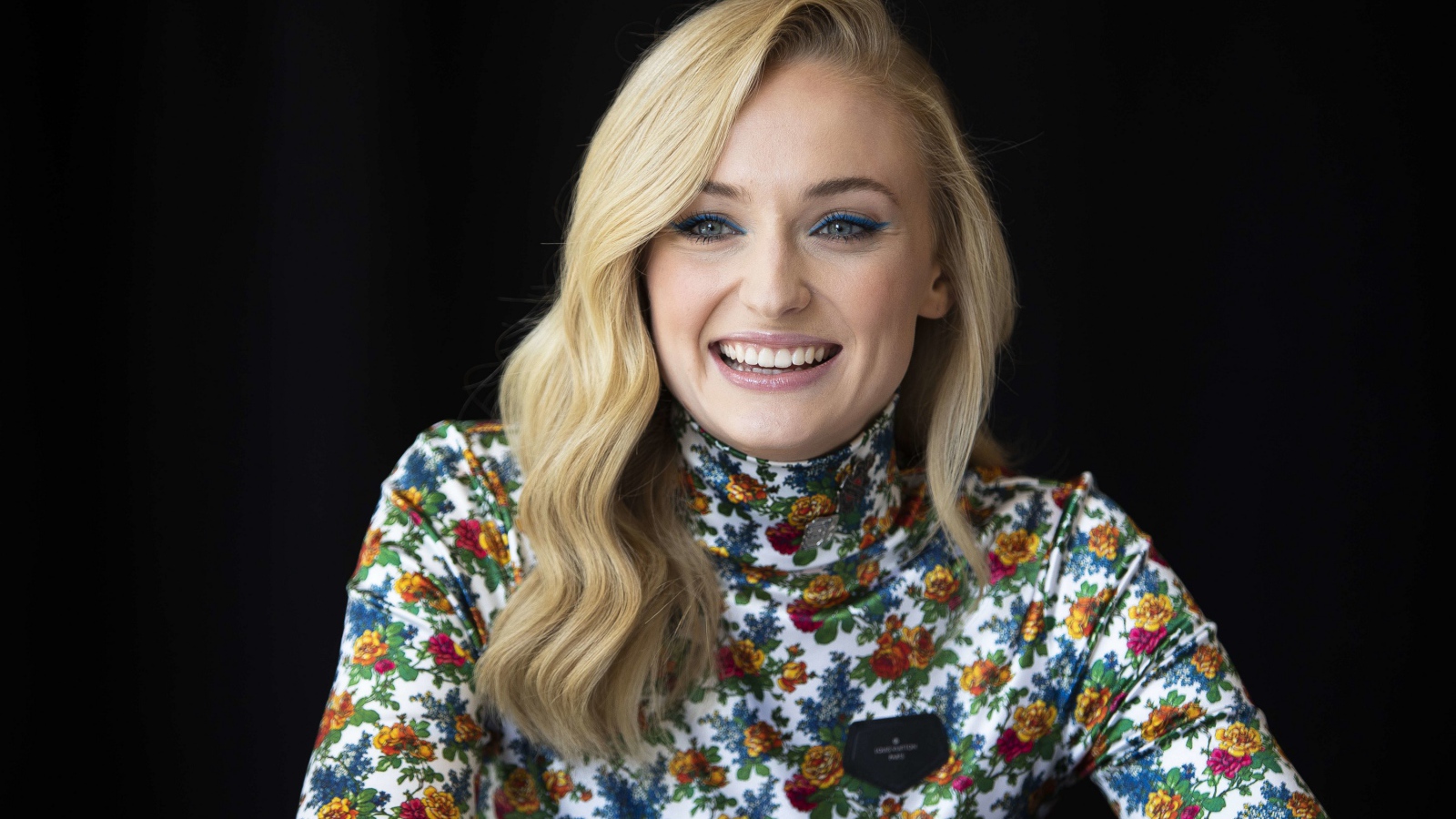 Очаровательная Софи Тёрнер улыбается на черном фоне