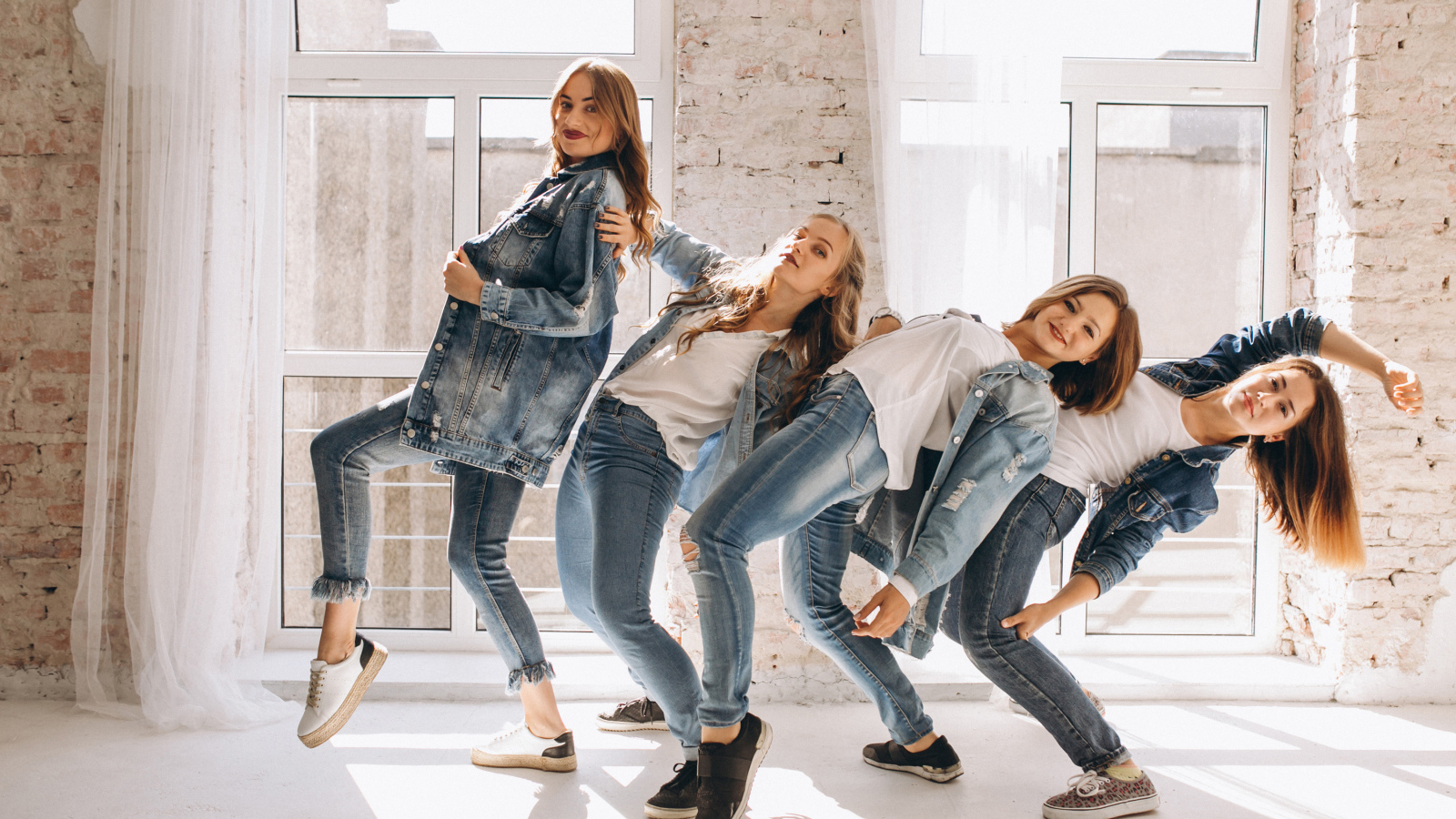 Четыре девушки в джинсовых костюмах занимаются танцами