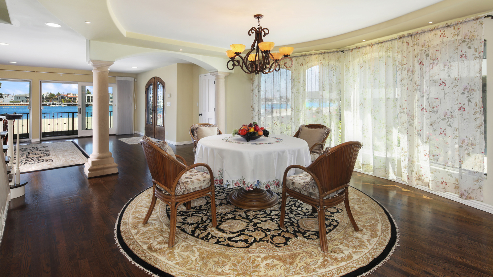 Большая гостиная комната с большими окнами и столом 