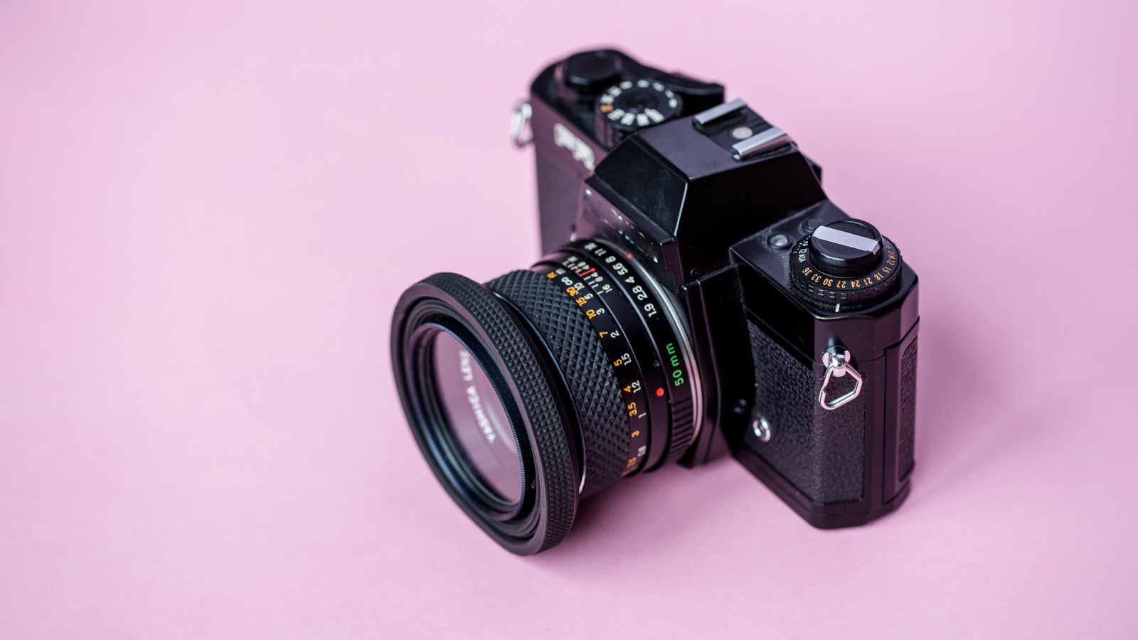 Старый фотоаппарат на розовом фоне