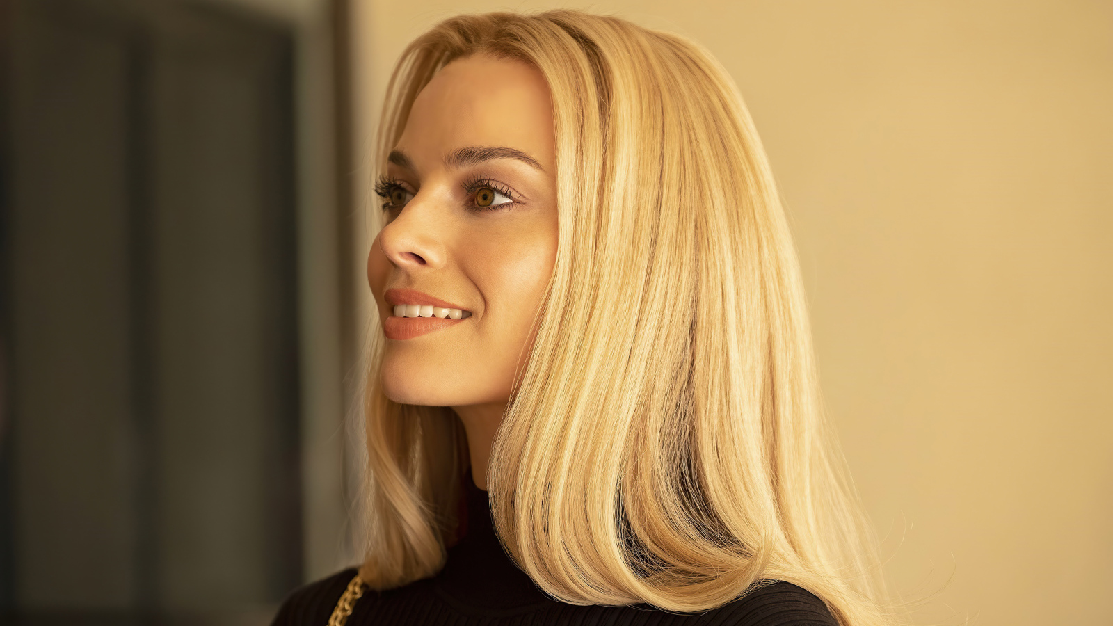 Улыбающаяся блондинка, актриса Марго Робби с карими  глазами