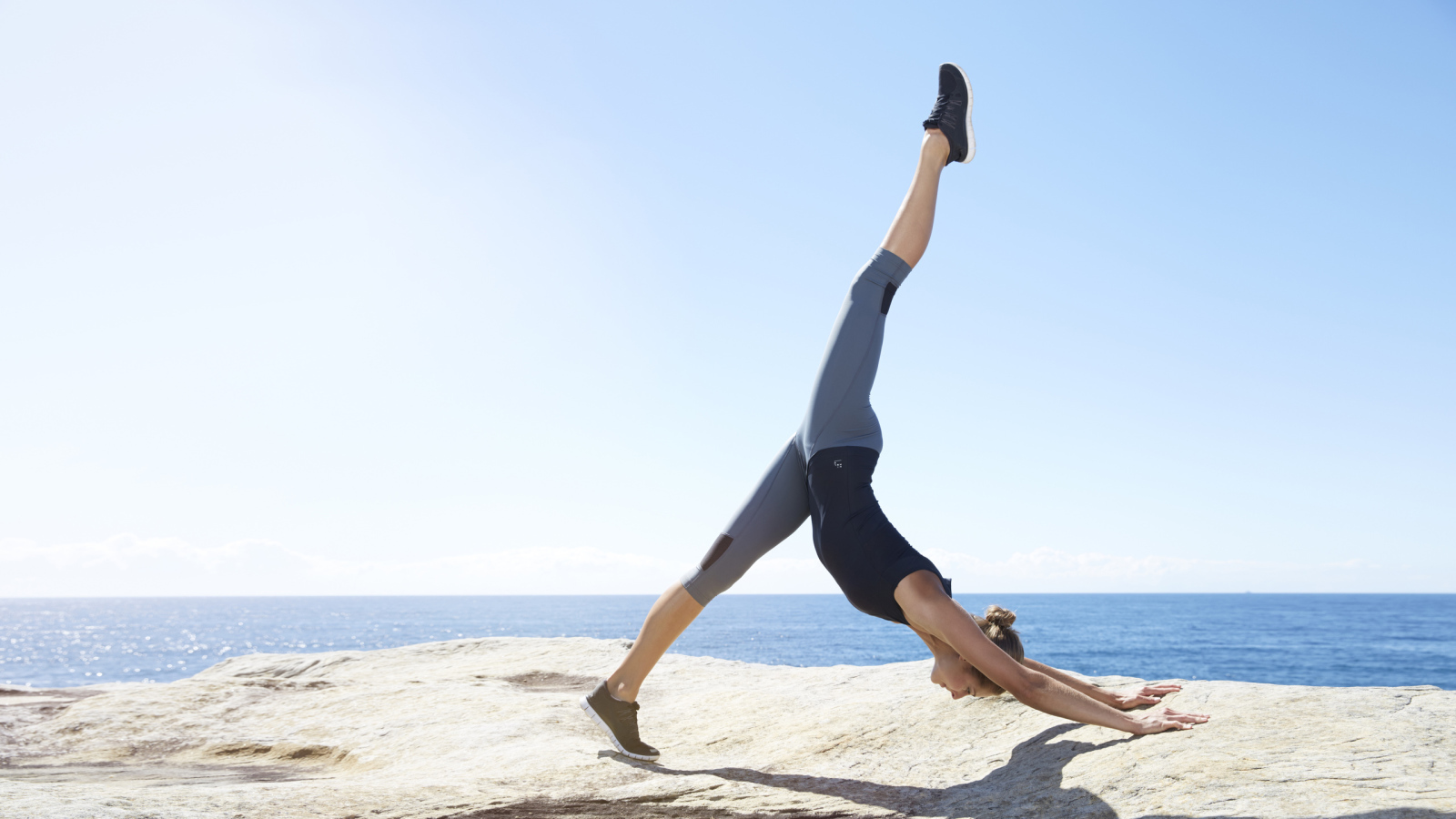 Спортивная девушка делает упражнения на берегу моря 