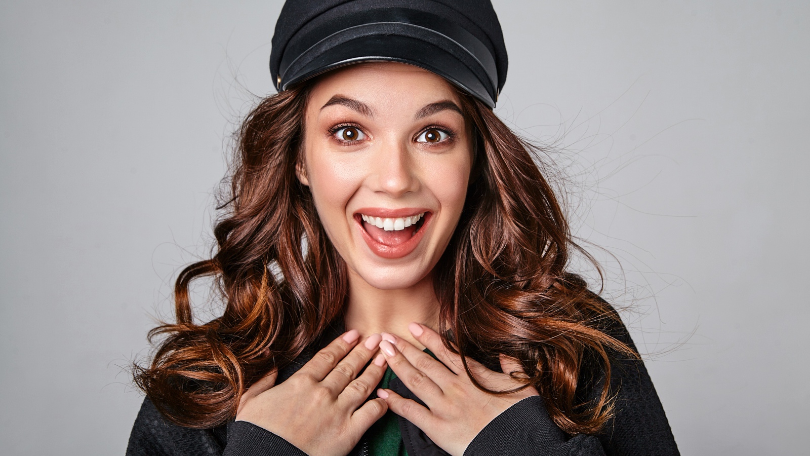 Удивленная кареглазая девушка в черной кепке