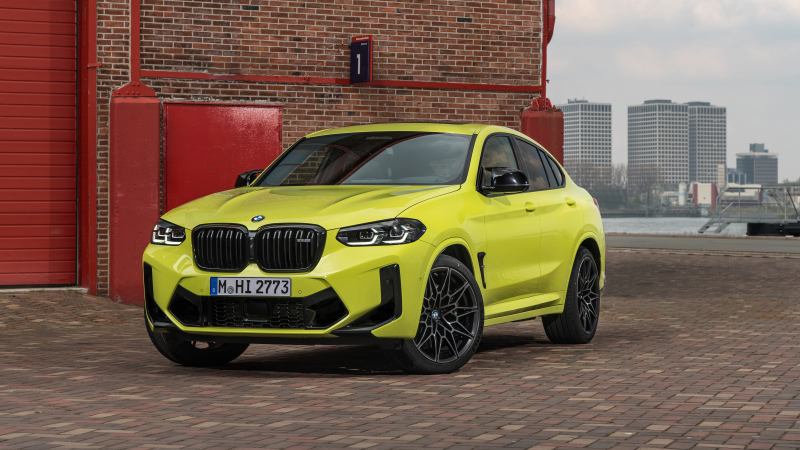 Желтый автомобиль BMW X4 M Competition 2021 года у стены