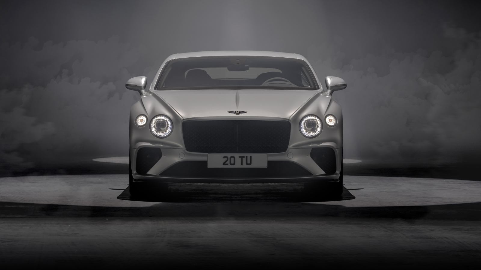 Серебристый автомобиль Bentley Continental GT Speed 2021 года на сером фоне