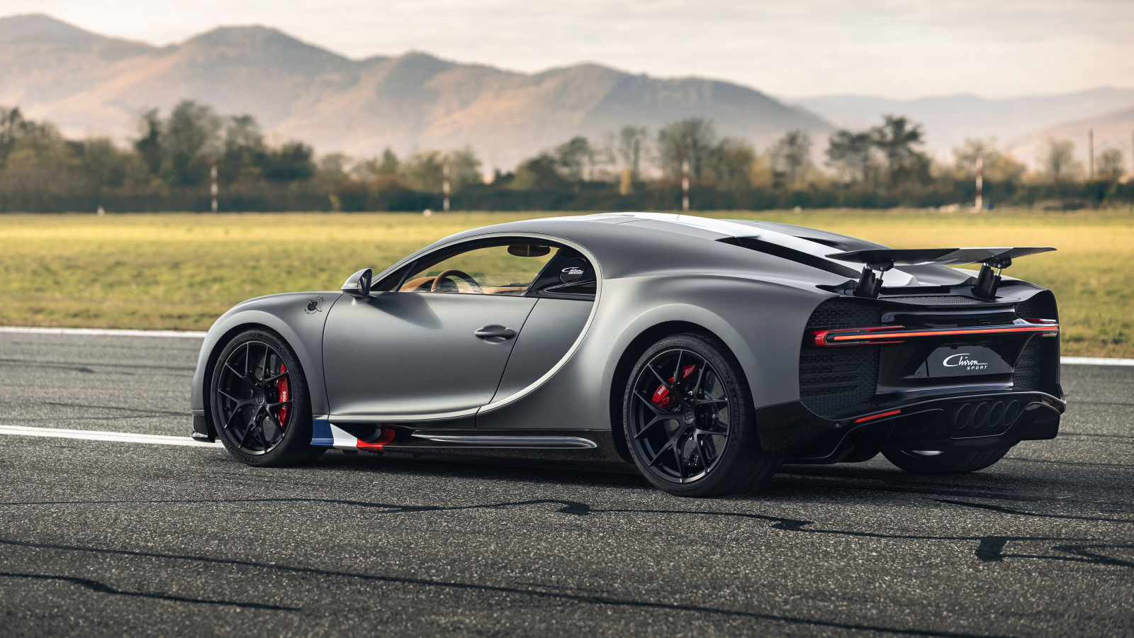 Серебристый спортивный автомобиль Bugatti Chiron  вид сзади