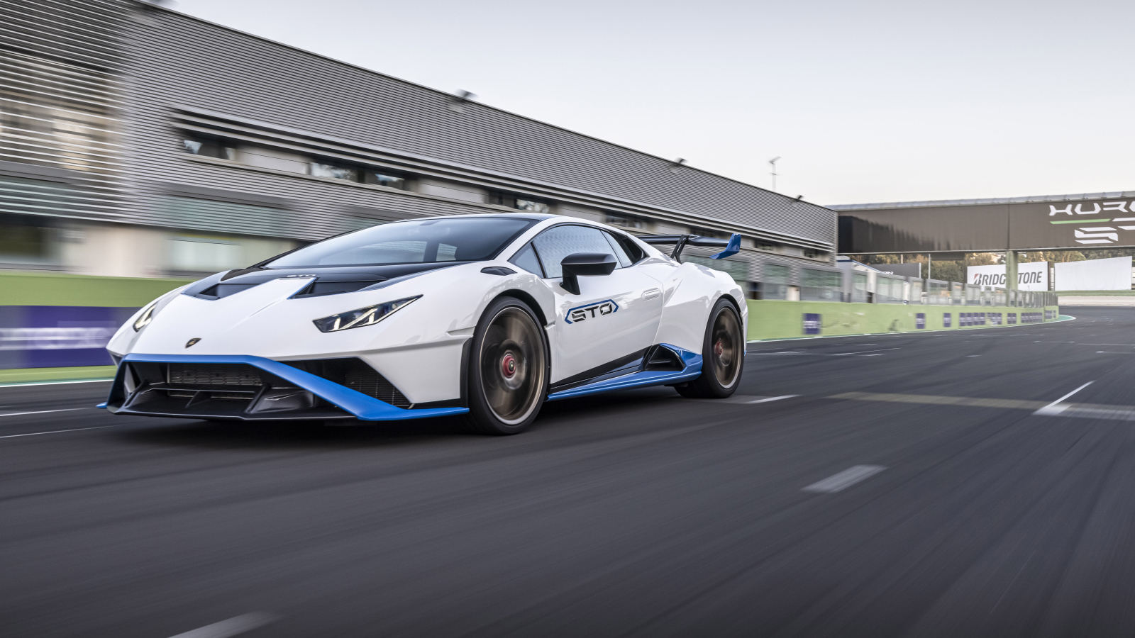 Белый автомобиль Lamborghini Huracán STO 2021 года на стадионе 