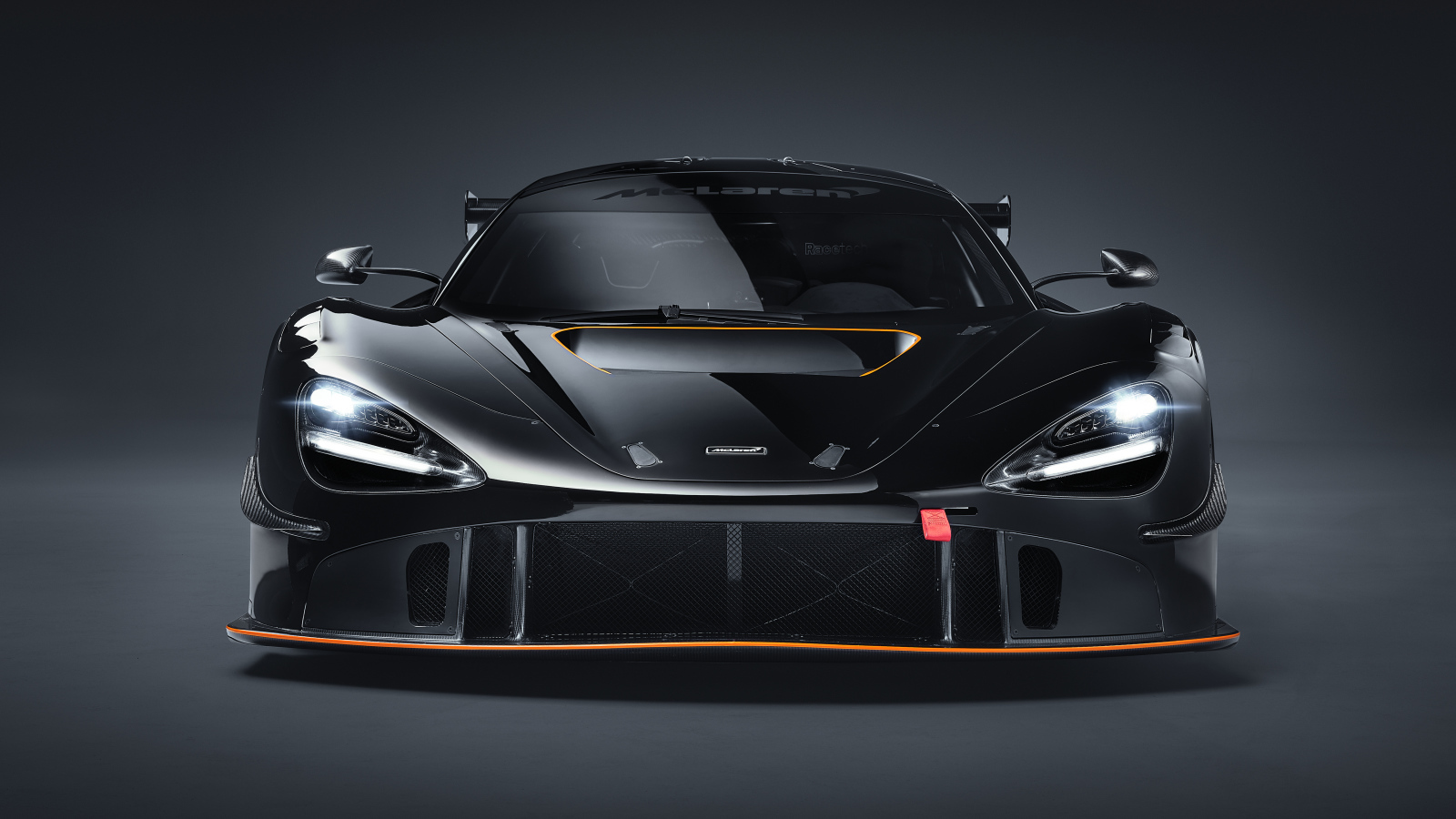 Автомобиль McLaren 720S GT3X 2021 года вид спереди на сером фоне