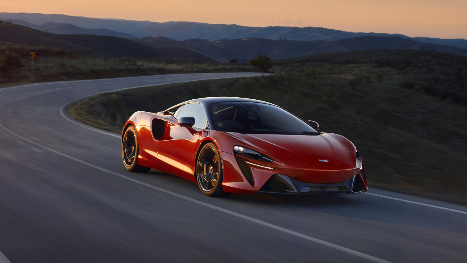 Красный автомобиль McLaren Artura, 2022 года на трассе