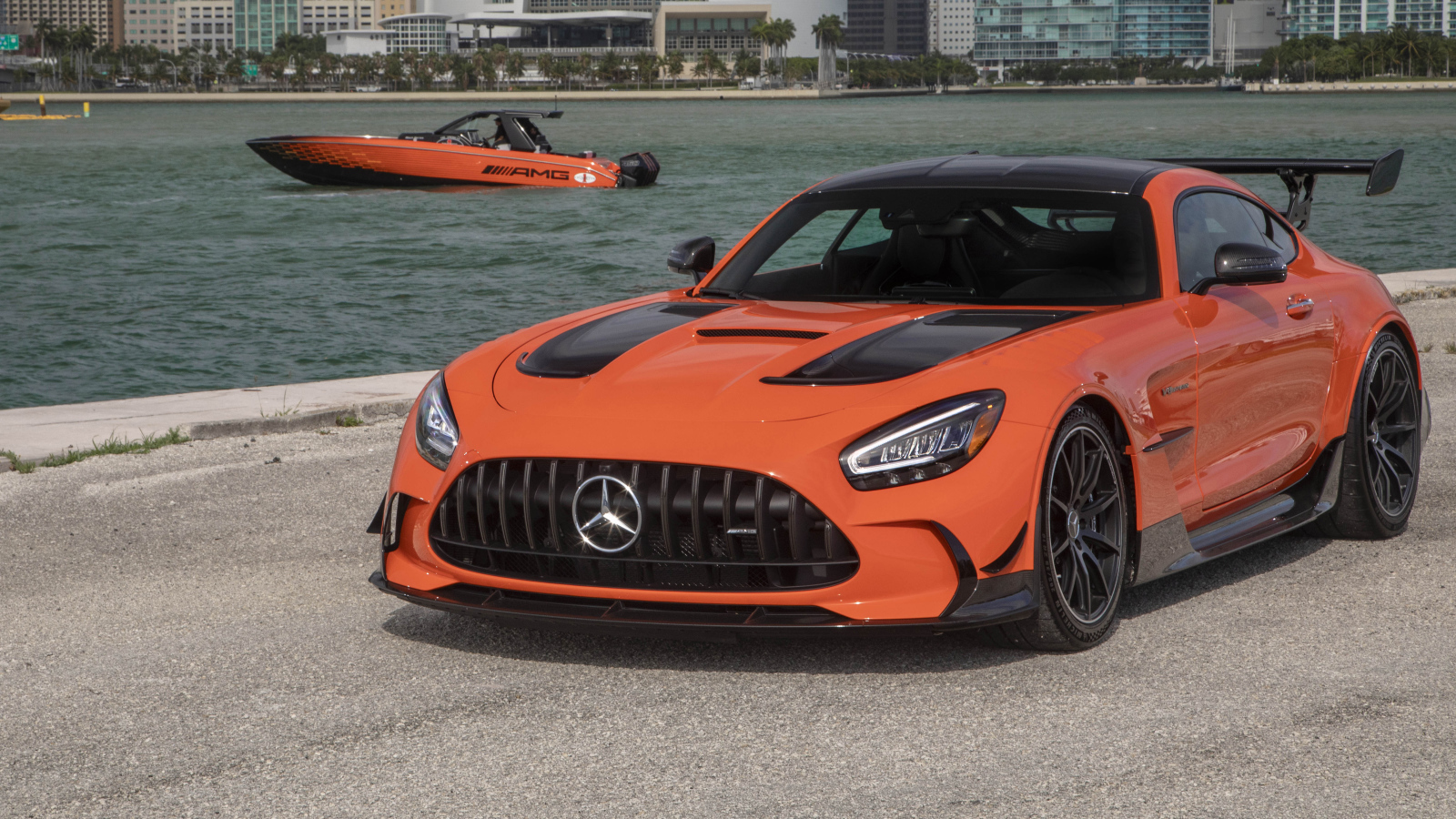 Оранжевый автомобиль Mercedes-AMG GT Black Series 2021 года у воды
