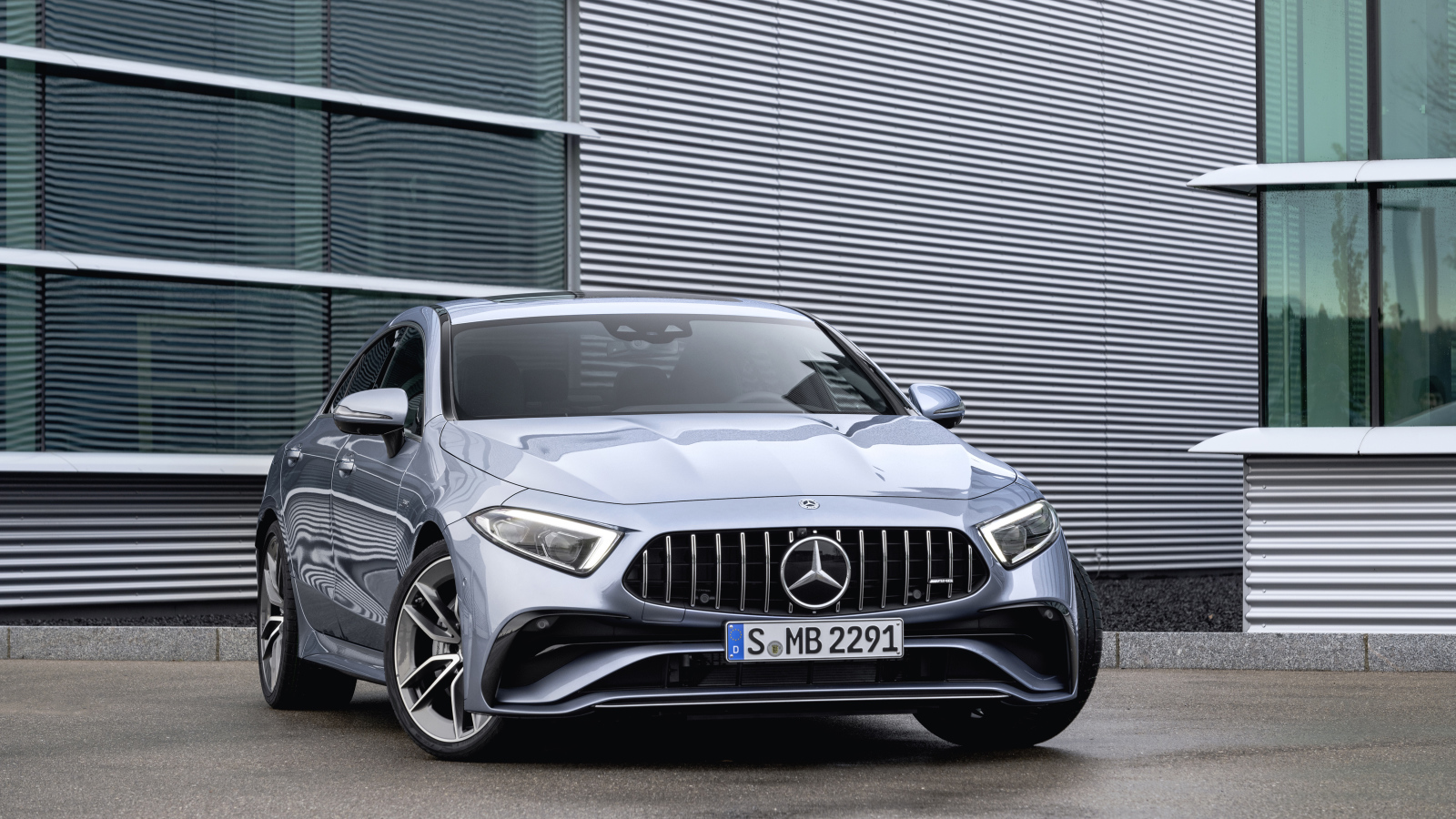 Серебристый автомобиль Mercedes-AMG CLS 53 4MATIC+ 2021 года у здания