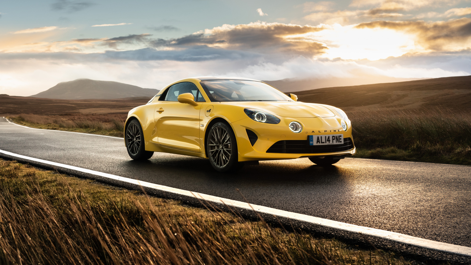 Желтый автомобиль Alpine A110, 2021 года на фоне заката