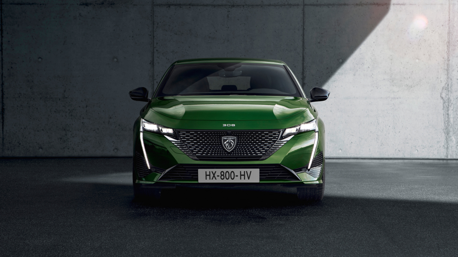 Автомобиль Peugeot 308, 2021 года вид спереди на фоне стены