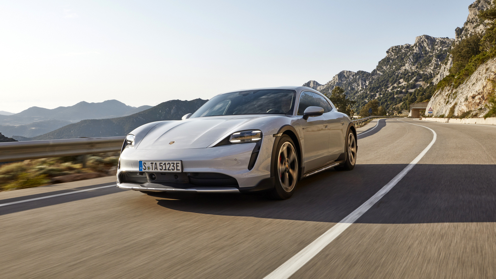 Автомобиль Porsche Taycan 4S Cross Turismo 2021 года на трассе в горах