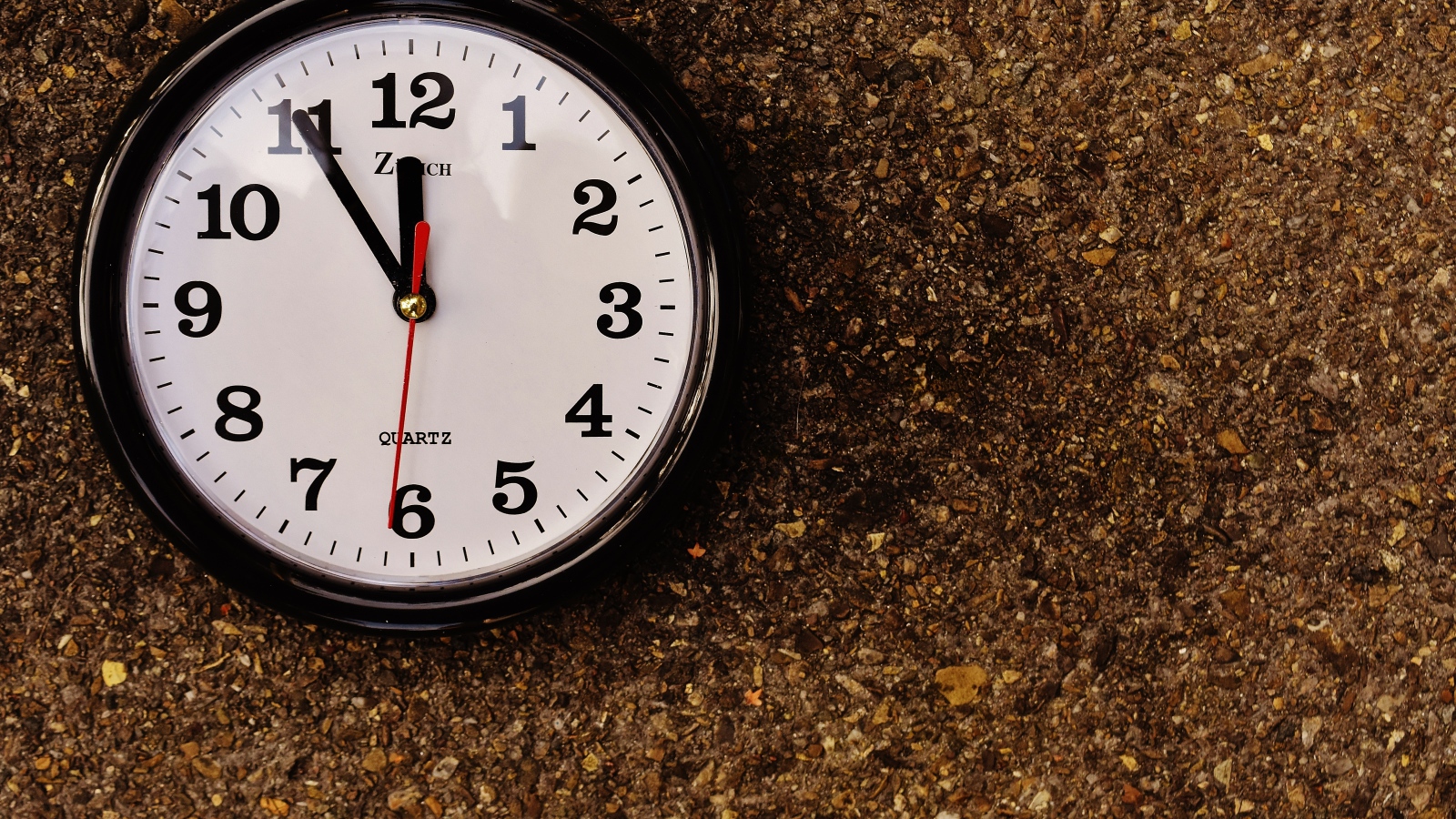 Большие черные часы висят на стене 