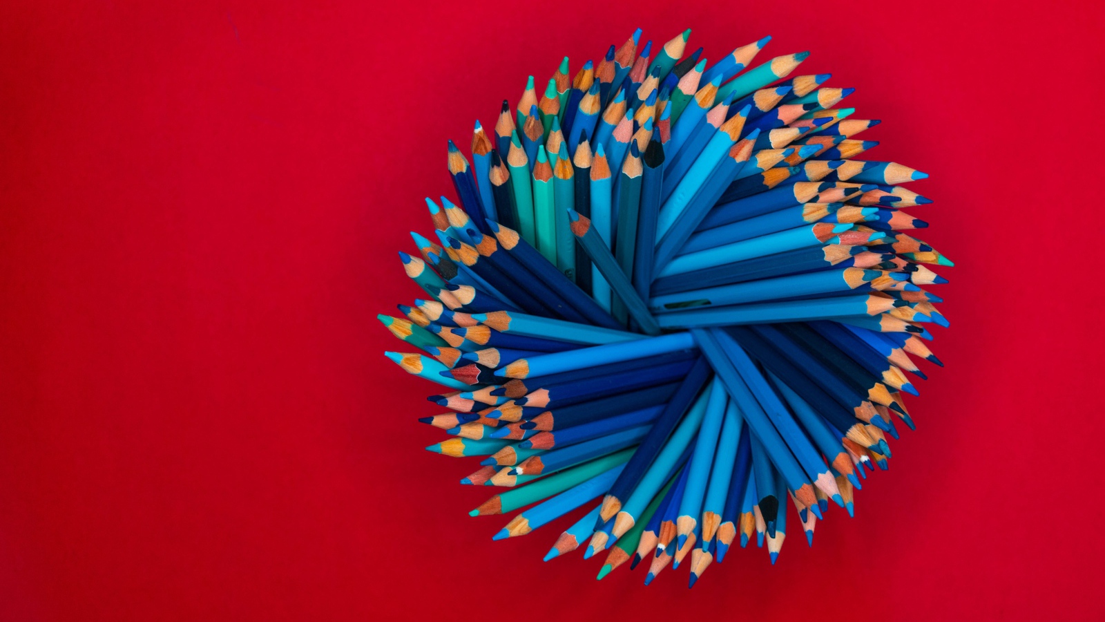 Синие карандаши на красном фоне