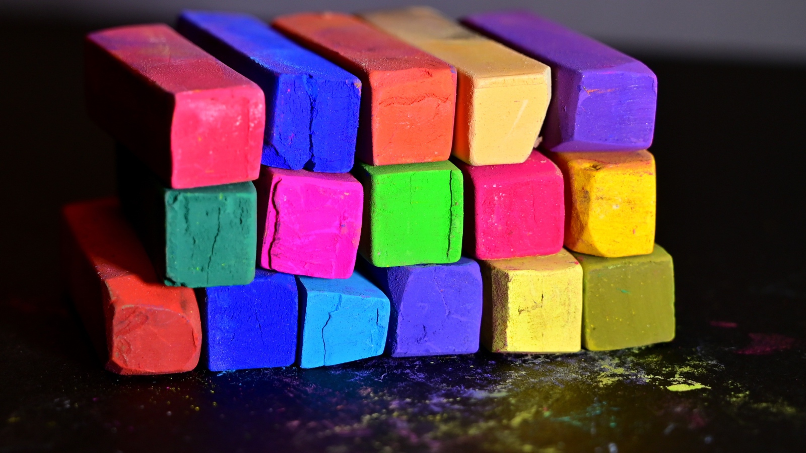 Разноцветные мелки для школы на черной поверхности 