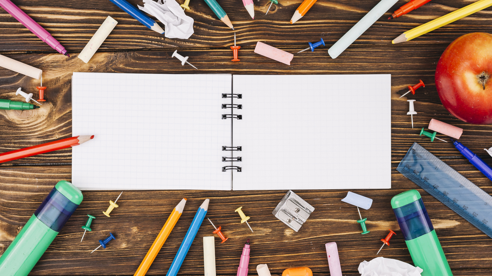 Открытый блокнот с ручками  на столе 