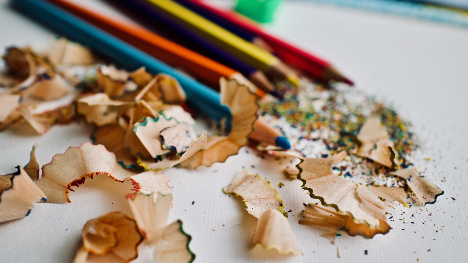 Карандаши со стружкой на сером столе 