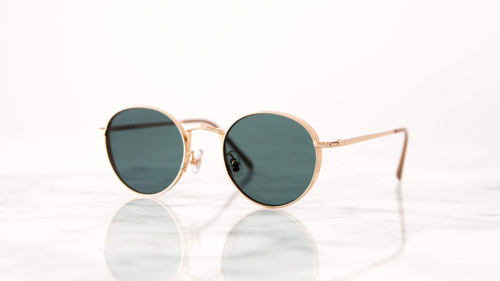 Солнечные очки лежат на зеркальной поверхности