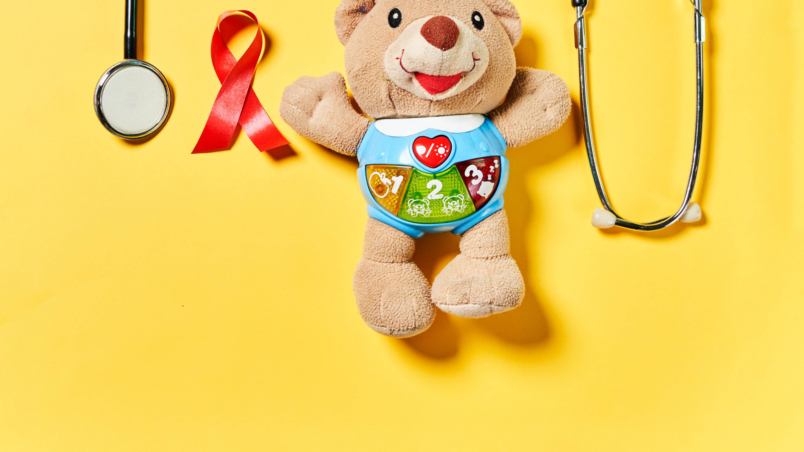 Игрушечный медвежонок с фонендоскопом на желтом фоне 
