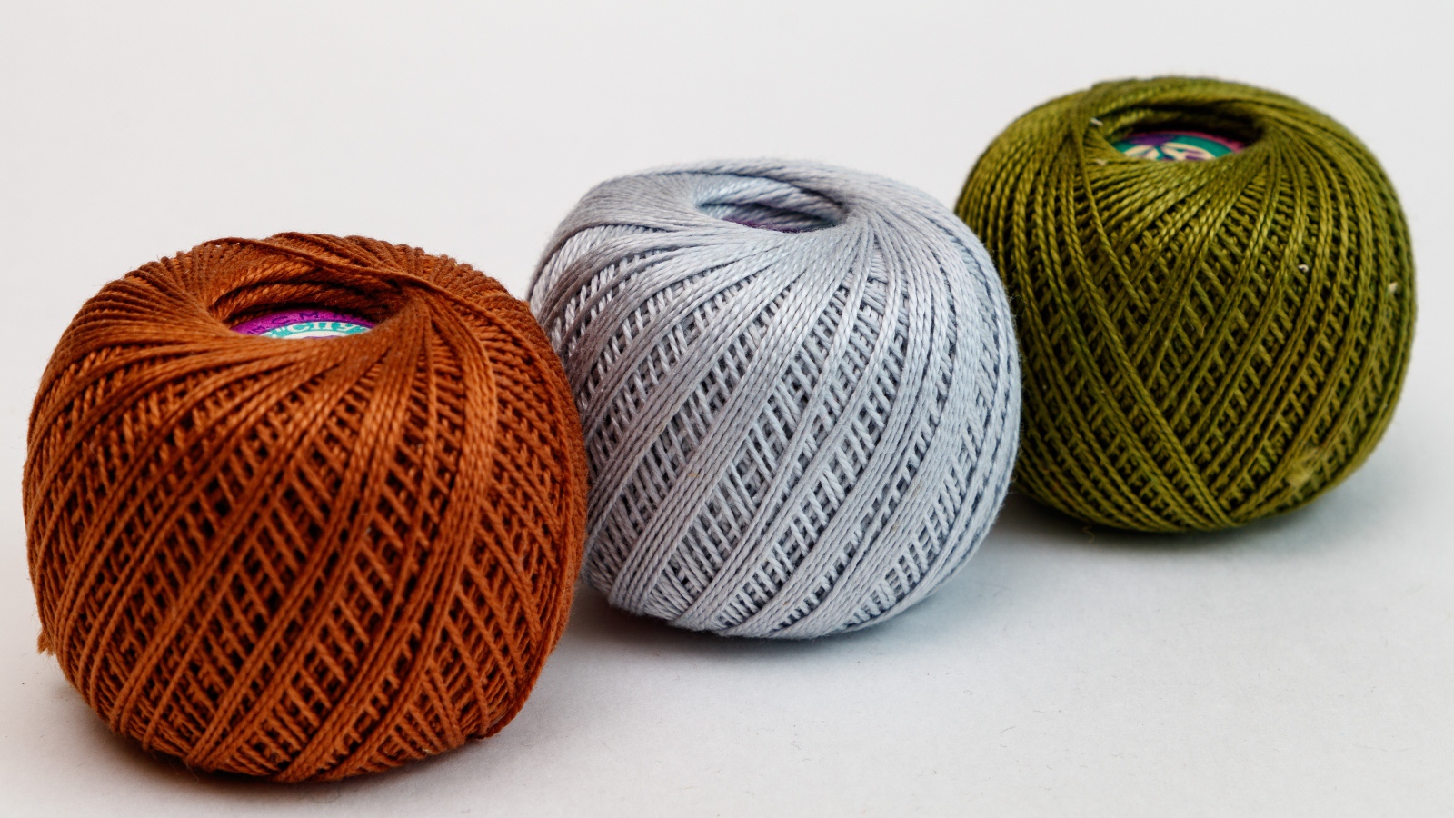 Три клубка пряжи на белом фоне 