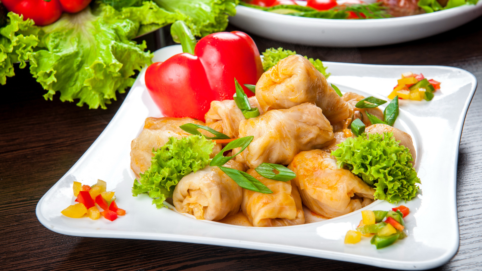 Аппетитные голубцы на тарелке с перцем 