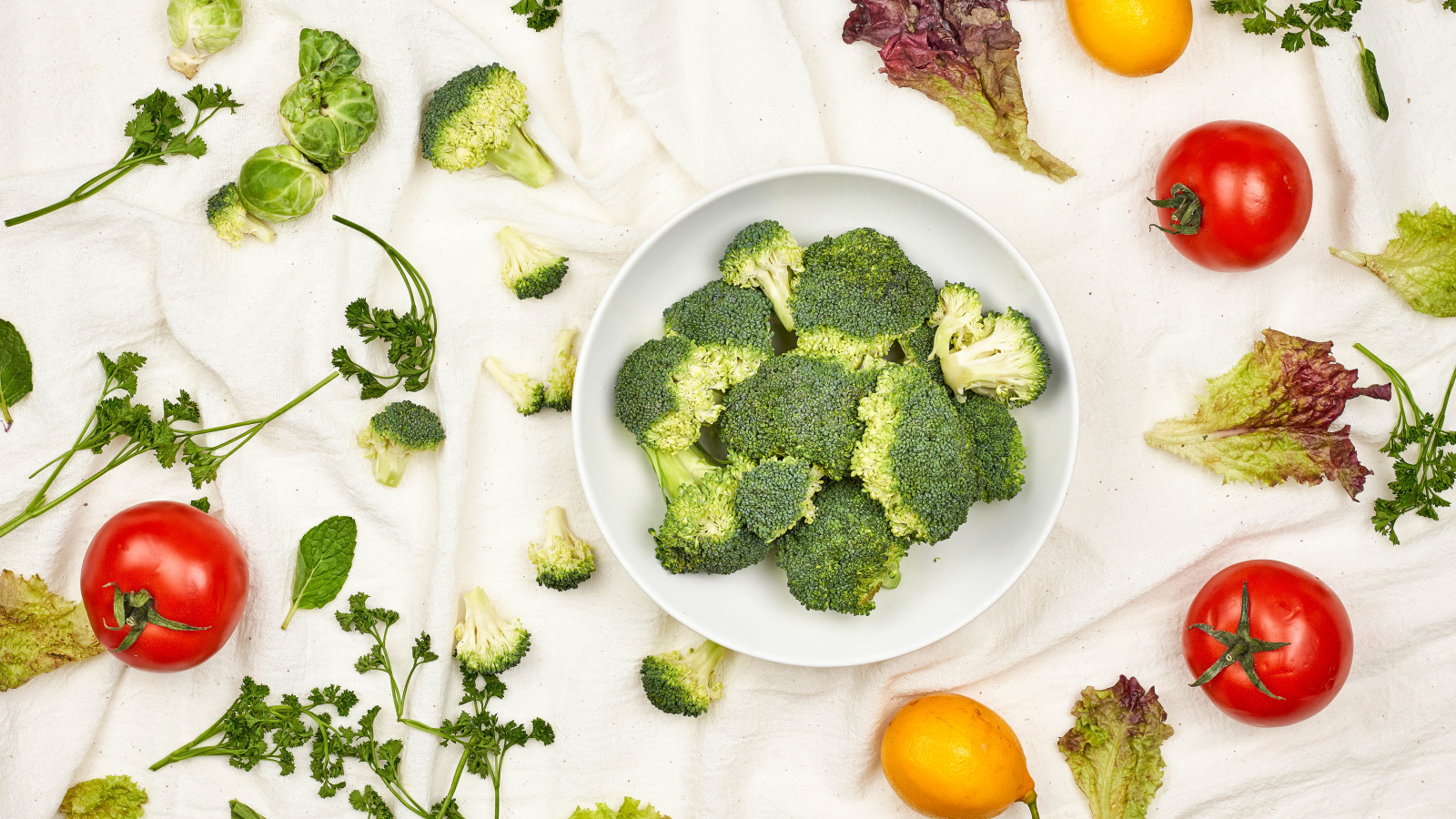 Брокколи на столе с помидорами и зеленью