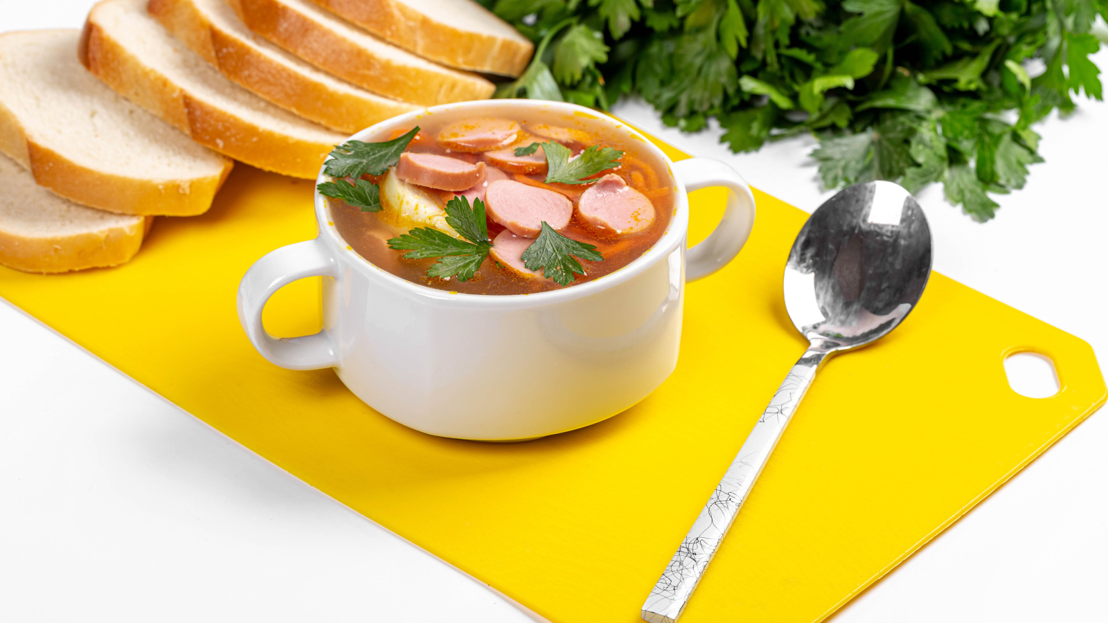 Вкусный суп солянка на столе с хлебом и петрушкой