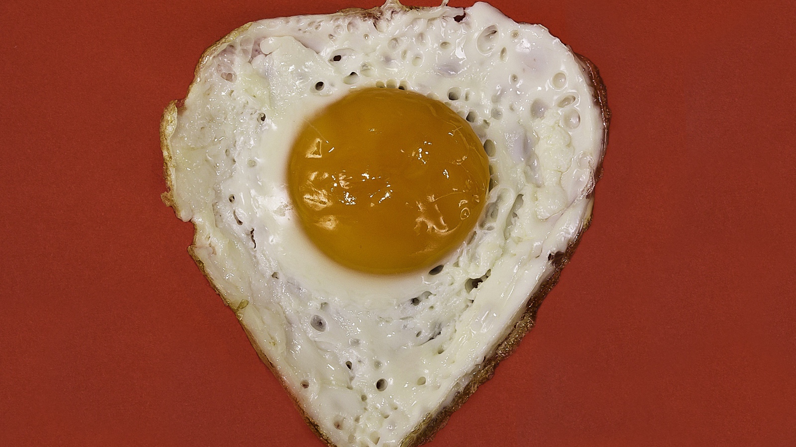 Яичница глазунья на красном фоне