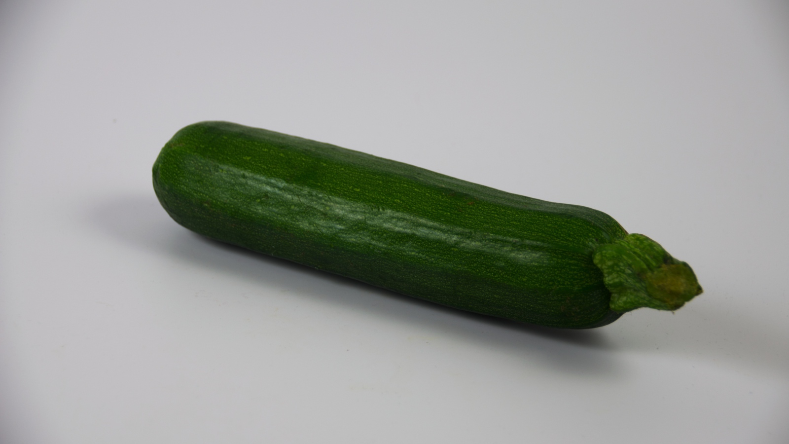 Зеленый кабачок на сером фоне